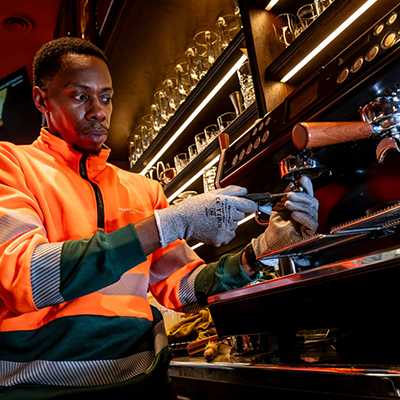 Un technicien répare une machine à café dans un bar