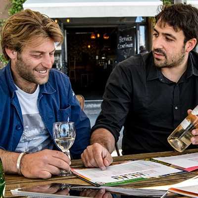 Un commercial France Boissons conseille un gérant d'établissement sur une gamme de vins