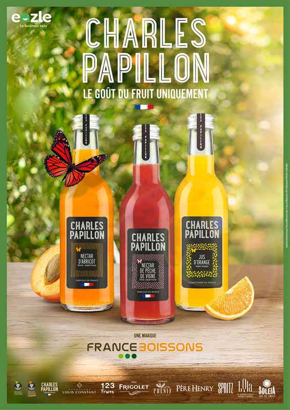 Deux bouteilles de jus Charles Papillon sur un bar avec un babyfoot en arrière-plan