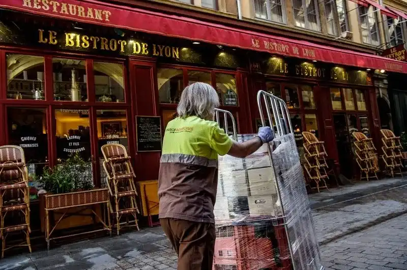 Livreur France Boissons avec un diable chargé devant la terrasse du Bistrot de Lyon