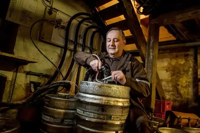 Technicien France Boissons raccordant des fûts de bière dans une cave à Strasbourg