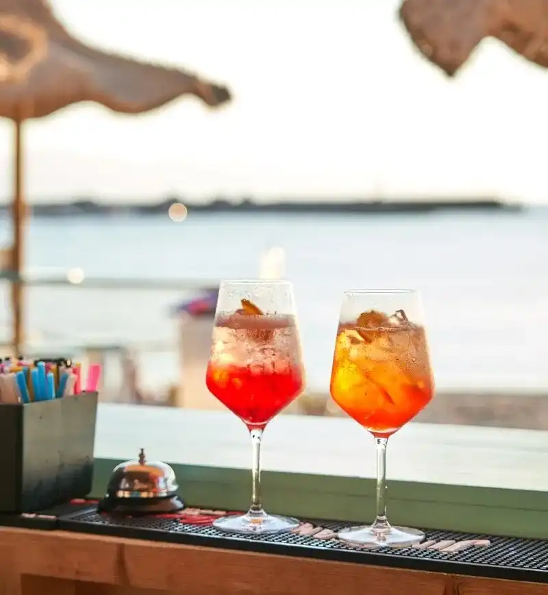 Deux spritz servis au comptoir d’un bar de plage face à la mer