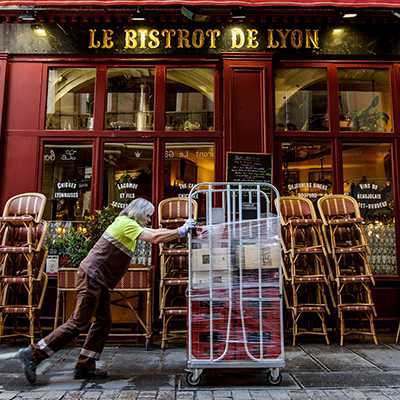 Un chauffeur-livreur France Boissons vient livrer des bouteilles et des fûts sur un charriot dans un bistrot