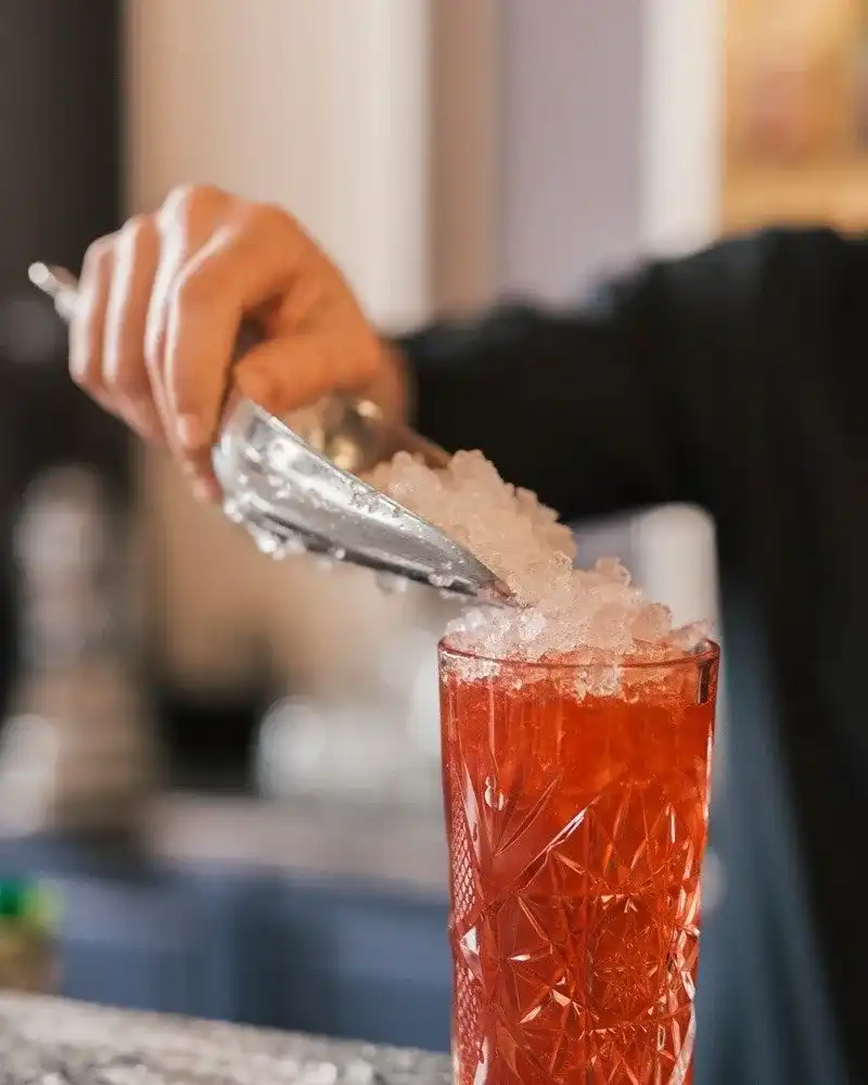 Barman préparant un cocktail avec de la glace pilée
